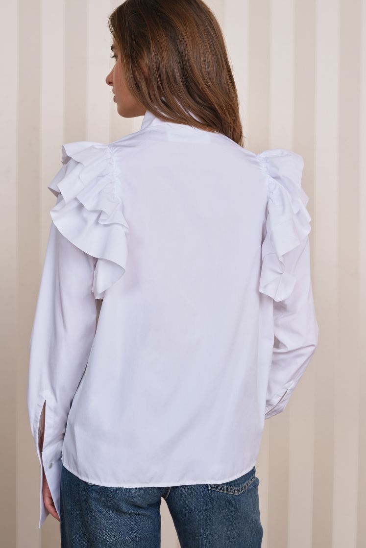 Femme de dos portant la chemise FORTUNÉE avec des volants sur les épaules. 