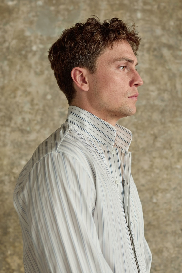 Chemise homme APPARAT rayée bleu et gris en coton avec un col haut, plan buste de profil. 