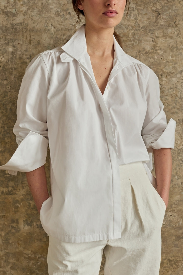 Chemise blanche oversize en coton avec col ouvert et manches retroussées, look élégant minimaliste intemporel