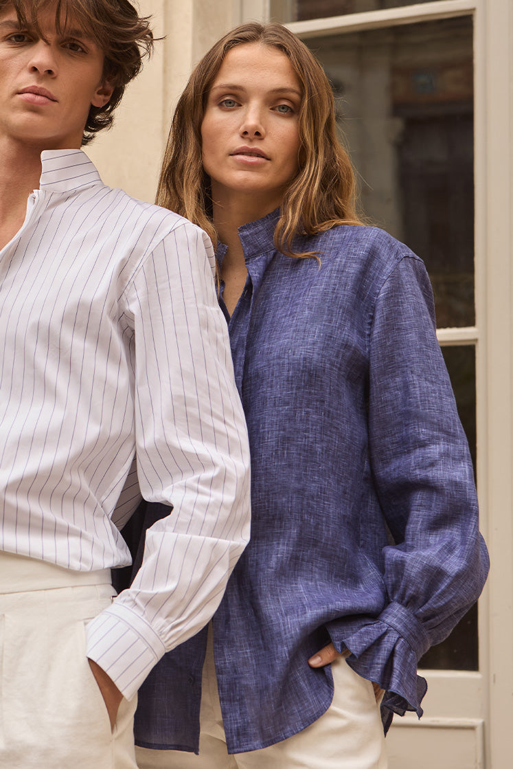 Femme portant une chemise en lin bleu marine, posant de face avec un homme en chemise blanche rayée.