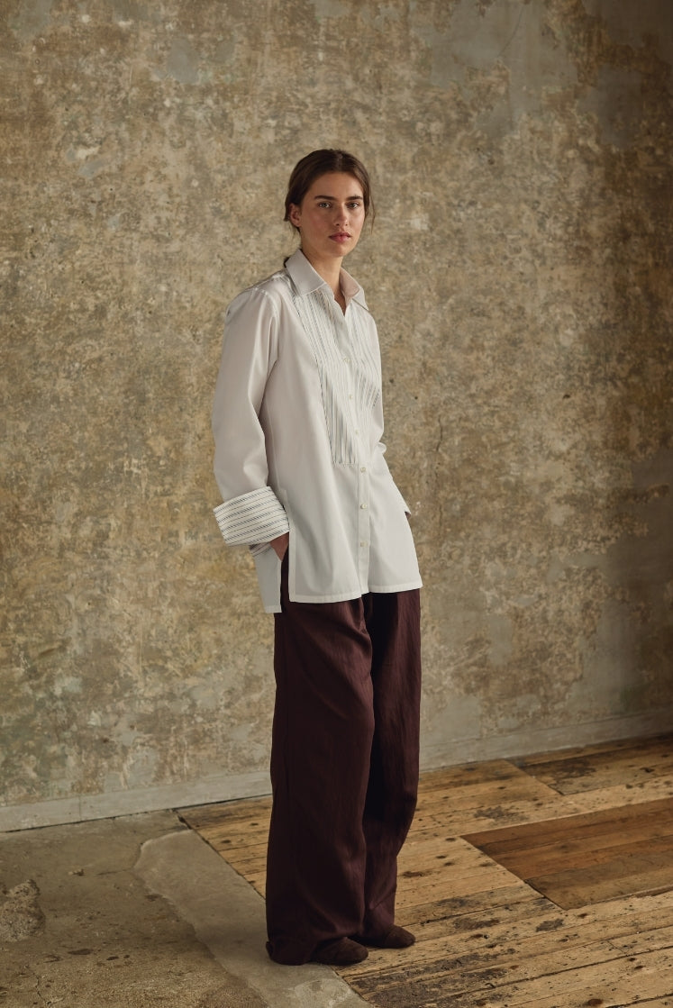 Femme portant une chemise blanche Bourrienne Paris avec plastron un plastron à rayures