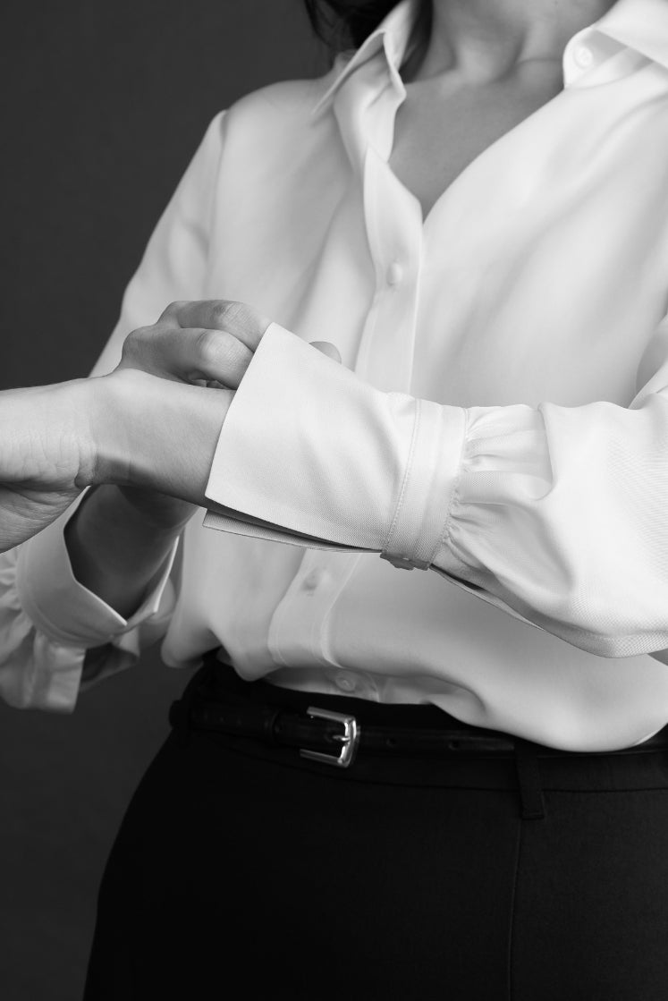 Close-up sur le poignet Bourrienne de la chemise NUMÉRO VII en soie blanche. 