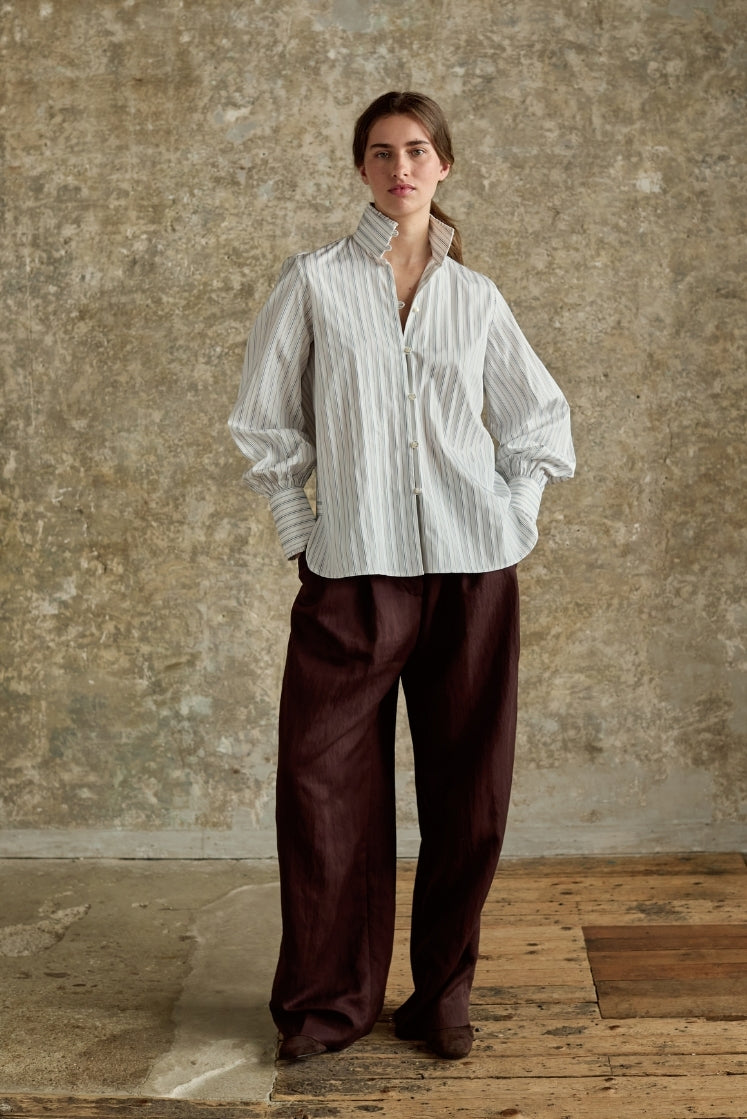 Chemise rayée gris bleu col haut portée avec pantalon marron large, élégance intemporelle Bourrienne