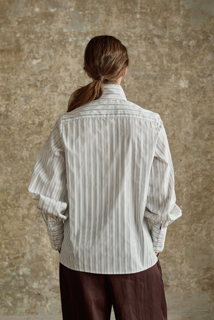 Chemise PRÉCIEUSE rayée bleu gris vue de dos, col haut et manches bouffantes, femme cheveux attachés