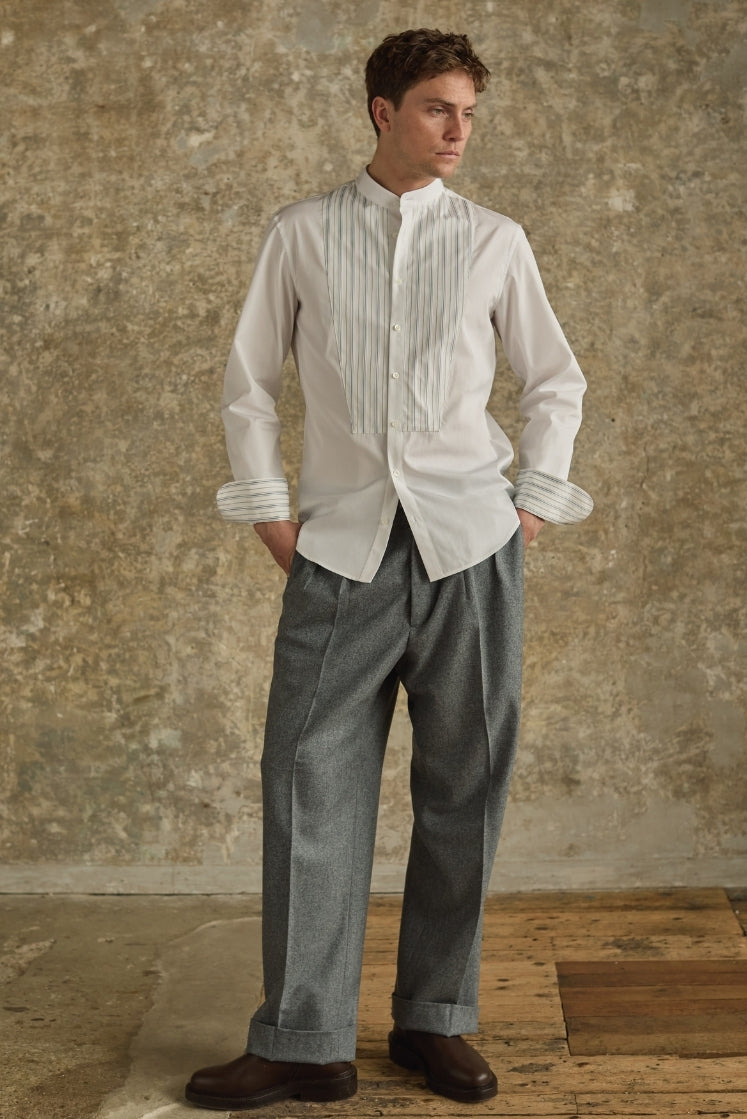 Chemise homme ROMANCIER en coton blanc avec plastron rayé bleu et gris, col officier et revers de poignets rayés, portée avec un pantalon gris. 