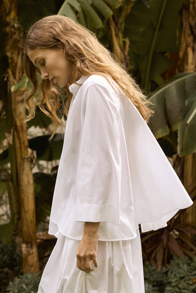 Femme portant la chemise blanche VAPOREUSE en voile de coton de profil, manches trapèze coupées 3/4