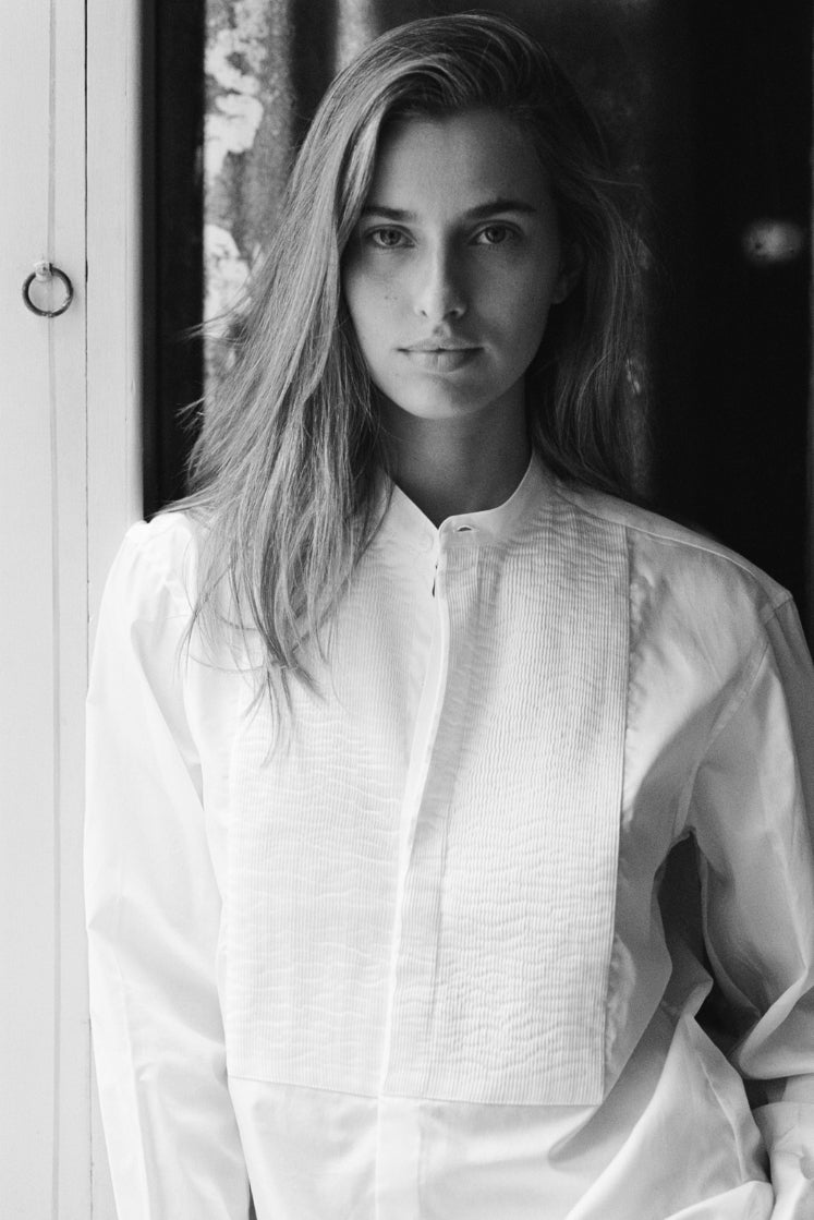 Femme portant la chemise COMÉDIENNE à col officier et plastron plissé à la main en Bretagne. 