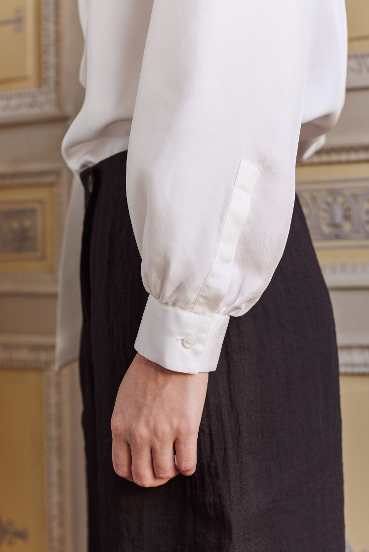 Close-up sur le poignet de la chemise blanche COMTESSE en soie. 