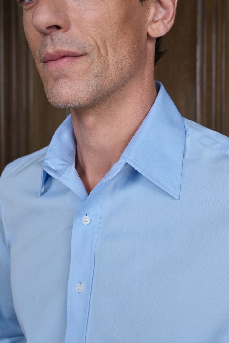 Homme portant une chemise bleu ciel à col français. 