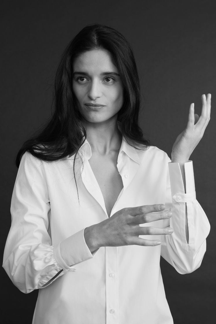 Femme portant une chemise blanche élégante, photographiée en noir et blanc, mettant en valeur le détail de la manche et du poignet Bourrienne.