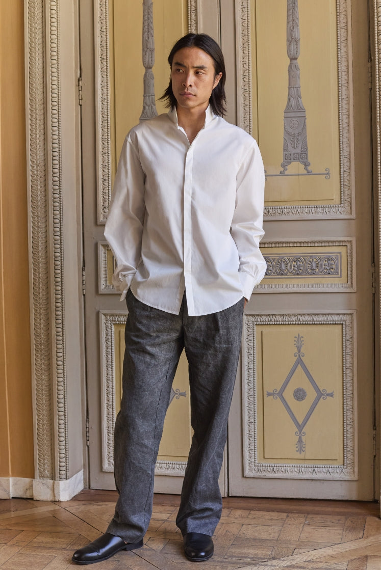 homme portant la chemise NUPTIALE en popeline de coton blanche à col haut et le pantalon HORIZON en lin plâtré gris