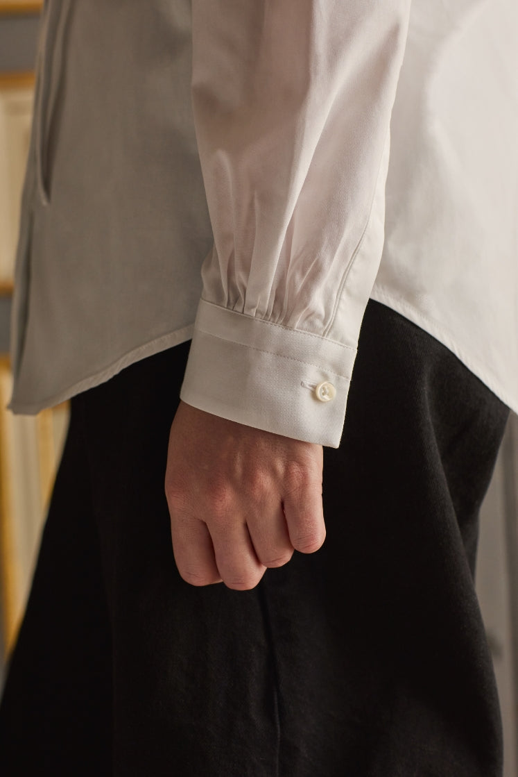 Close-up sur le poignet classique de la chemise PASTEL blanche en popeline de coton. 
