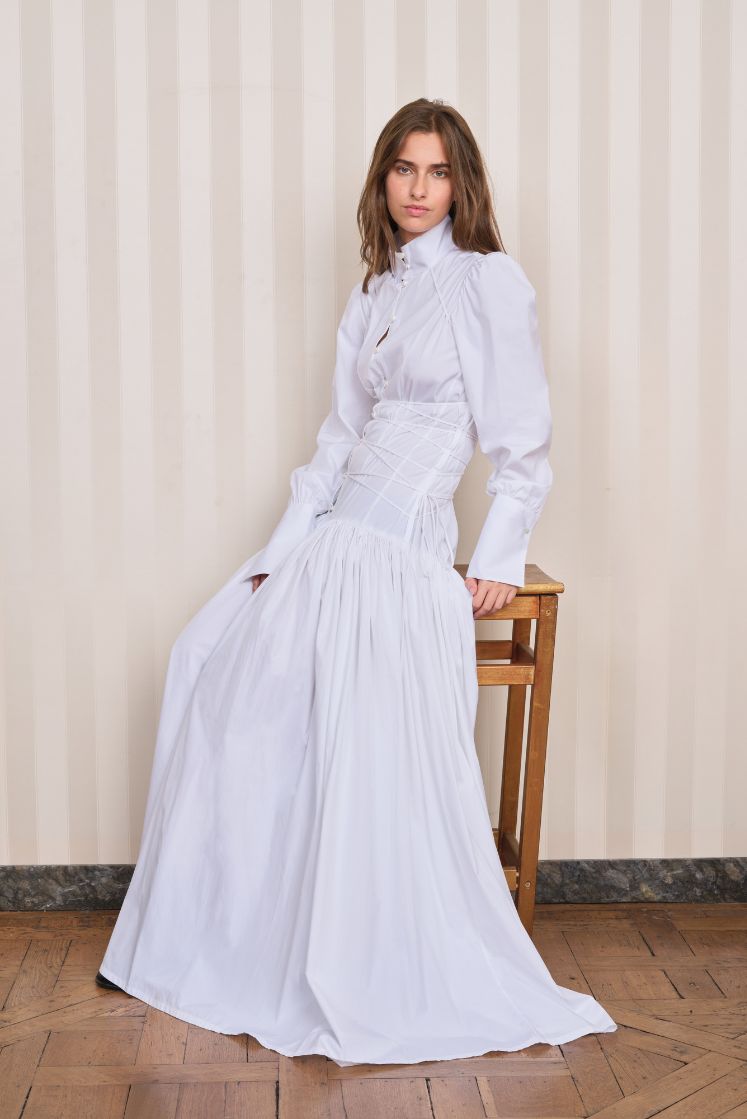 Femme assise sur un tabouret portant la robe-chemise longue à corset JOSÉPHINE. 