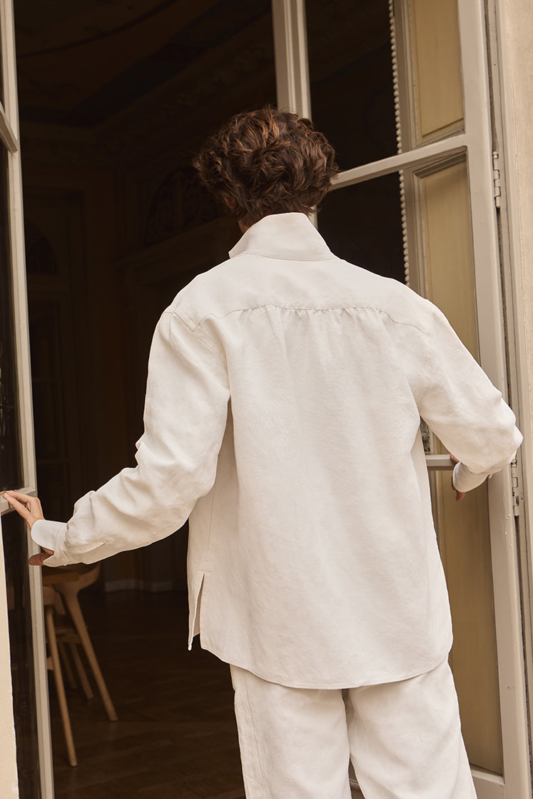 Homme portant la surchemise ASTRE en lin épais, de dos, on peut distinguer une série de fronces placées dans le dos de la surchemise pour donner du volume.