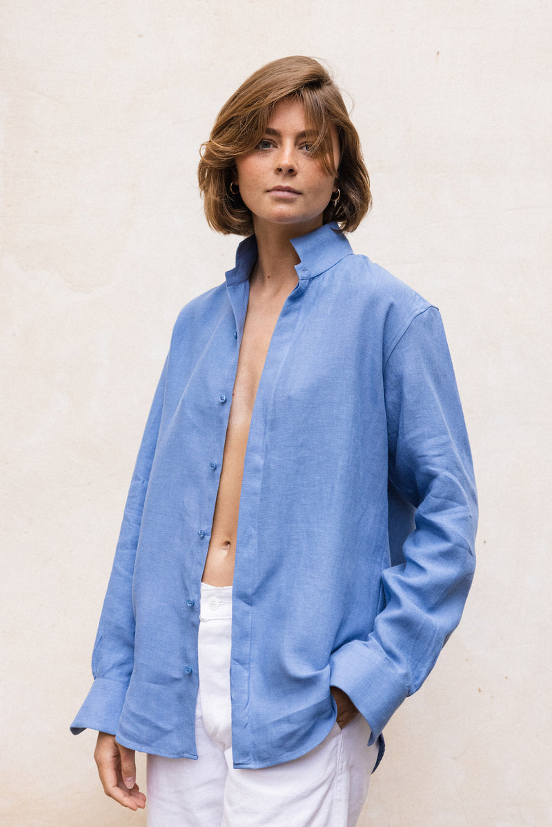 La chemise AMAZONE en bleu, pièce centrale de la collection Bourrienne, revisite élégamment le col ancien et présente des fronces distinctives à l'arrière, ajoutant une touche de raffinement et élégance.