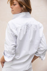 La chemise AMAZONE, pièce centrale de la collection Bourrienne, revisite élégamment le col ancien et présente des fronces distinctives à l'arrière, ajoutant une touche de raffinement et élégance.
