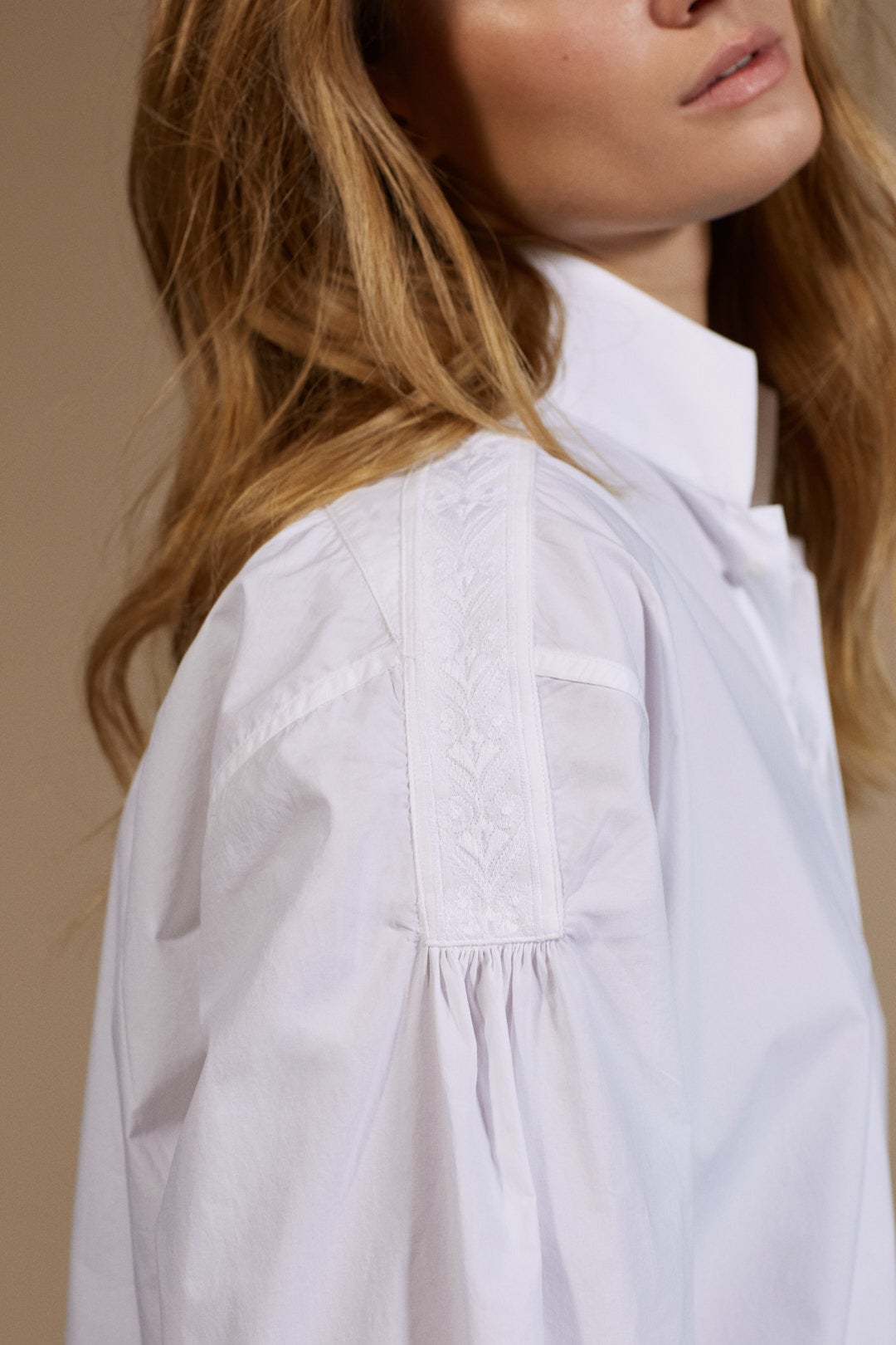 Chemise Femme Haut de gamme 100% coton col haut avec broderie sur la ligne des épaules. Vue épaules focus broderie..